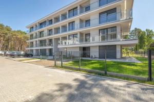 an apartment building with a fence in front of it at Urokliwy Apartament z Ogródkiem 150 m od Plaży Parking Międzywodzie by Noclegi Renters in Międzywodzie +36 photos