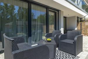 a group of chairs and a table on a patio at Urokliwy Apartament z Ogródkiem 150 m od Plaży Parking Międzywodzie by Noclegi Renters in Międzywodzie