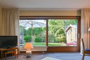 un soggiorno con una porta scorrevole in vetro con vista sul giardino di Bungalow Mumm a Dahme