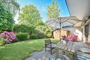 un patio con tavolo, sedie e ombrellone di Bungalow Mumm a Dahme