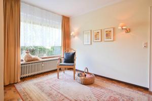 una stanza con una sedia e una finestra con un pollo di Bungalow Mumm a Dahme Altre 7 foto