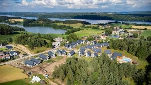 an aerial view of a village with a lake at Willa 27 Lakeside Retreat Łączyno by BookingHost in Łączyno