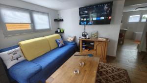 Una sala de estar con un sofá azul y un televisor. en La Hasienda, en Geldern