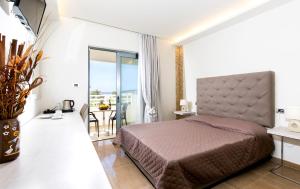 a bedroom with a bed and a balcony at Maroula Blue Studios & Suites in Faliraki