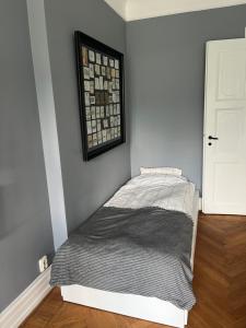 a bedroom with a bed with a picture on the wall at Fria Bad in Helsingborg