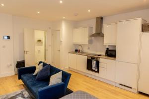 a living room with a blue couch in a kitchen at New! Central & Cosy with Smart TV, Book Your Stay! in Maidstone