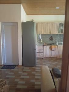 a kitchen with a refrigerator in the middle of a room at Nino's Home in Borjomi +6 photos