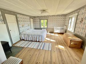 a bedroom with a bed and a wooden floor at Family-friendly countryside house close to lake in Skärås