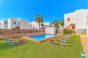 a backyard with a swimming pool and two lawn chairs at Villa Mar Egos by Villa Plus in Cacla D'or