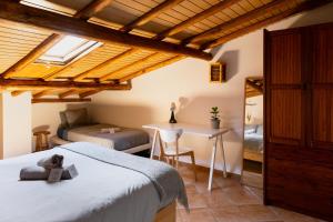a bedroom with a bed and a desk in a room at Aldeia Caiçara Surf House in Sagres