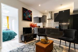 ein Wohnzimmer mit zwei Stühlen und eine Küche in der Unterkunft NEW Spacious House 6 Bedrooms 4Bathrooms 10 Guests in Romford