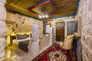 a bedroom with a bed in a room with a stone wall at Kayatas Cave Suites in Goreme +142 photos