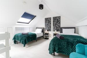 1 Schlafzimmer mit 2 Betten und einem blauen Stuhl in der Unterkunft NEW Spacious House 6 Bedrooms 4Bathrooms 10 Guests in Romford