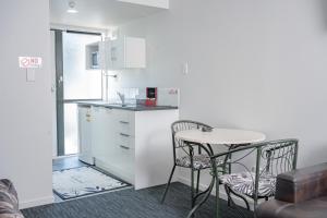a small kitchen with a table and two chairs at Samhil Motor Lodge in Christchurch