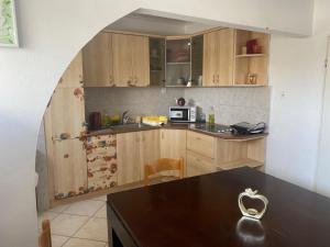 a kitchen with wooden cabinets and a table with a heart on it at Guest house Циммер Дора, Мертвое море in Neve Zohar