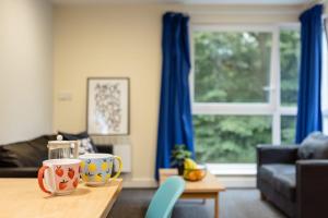 ein Wohnzimmer mit einem Tisch, auf dem zwei Tassen stehen in der Unterkunft Bonington Student Village in Suton Bonington in Sutton Bonington
