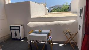 a table and chairs on a balcony with a window at Casa Lilian in Stromboli