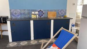 a blue kitchen with a blue counter and a chair at Casa Lilian in Stromboli +10 photos