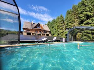 a large swimming pool in front of a house at Noclegi Pod Małym Królem in Ustrzyki Dolne