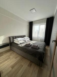 Un dormitorio con una cama con dos toallas encima. en Apartment on Protozanova 21, en Öskemen
