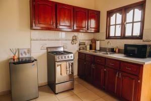 a kitchen with wooden cabinets and a stainless steel stove at Casita Catiri - Cozy Guesthouse with a Pool in Noord +14 photos