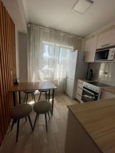 una pequeña cocina con mesa, 2 sillas y mesa en Apartment on Protozanova 21, en Öskemen 9 fotos más