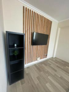 Una sala de estar con un televisor de pantalla plana en una pared. en Apartment on Protozanova 21, en Öskemen