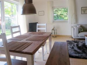 sala de estar con mesa de madera y sillas en Ferienhaus Schillo en Rangsdorf