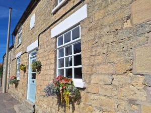 a brick building with a window with flowers on it at Boundcliffe Farm in Allerston