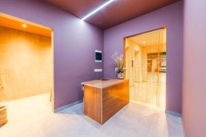 a bathroom with purple walls and a wooden desk at Saranda Seaview Spot in Sarandë