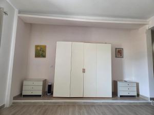 a white cabinet in a room with two dressers at Bellavista Monolocale in Foligno +1 photo
