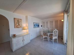 a dining room with a table and chairs at APARTAMENTO Los CISNES in Benalmádena