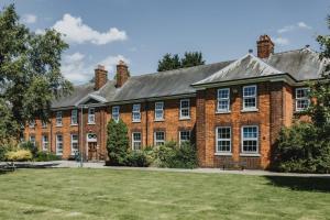 ein großes rotes Backsteingebäude mit einem Rasenplatz in der Unterkunft Bonington Student Village in Suton Bonington in Sutton Bonington