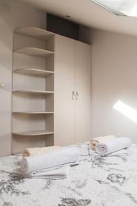a room with white cabinets and towels on a table at BACINELLA apartmani in Baćina +30 photos