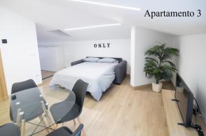 una camera da letto con un letto, delle sedie e una pianta di Apartamentos LA PARRILLA a La Parrilla Altre 32 foto