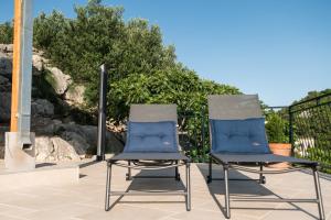 two chairs sitting next to each other on a patio at BACINELLA apartmani in Baćina