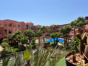 a view of a resort with a pool and palm trees at Duplex Imiouaddar in Imi Ouaddar