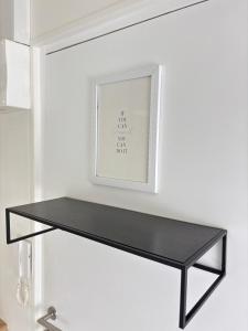 een zwarte plank in een witte kamer met een foto bij Soh Rent Strasbourg Studio 3 Tv-Wifi Proche Gare in Straatsburg