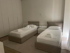 two twin beds in a room with a window at Green Coast 60b - by Ale Investa in Palasë