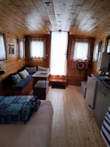 a room with a bed and a couch in a cabin at 2-person gîte on Laïta boat in Cheffes-sur-Sarthe