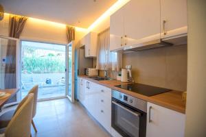 eine Küche mit weißen Schränken und einem Tisch mit Stühlen in der Unterkunft Sidonia Suite in Psari Forada