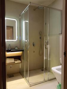 バンガロールにあるHotel Muthahalli Grandのシャワーと洗面台付きのバスルーム +18枚の写真