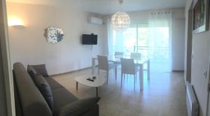 a living room with a couch and a table with chairs at R&eacute;sidence Beau rivage in Algajola