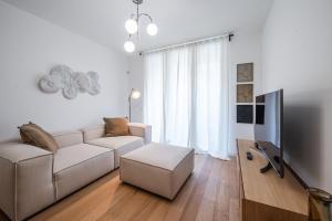 ミラノにあるMilano Navigli - Charme & Design LUXURYのソファとテレビのある白いリビングルーム