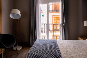 a bedroom with a bed and a large window at Hotel Puerta del Mar - Adults Recommended in Nerja