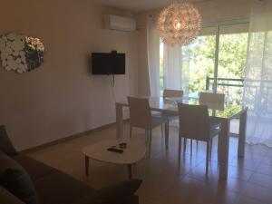 a dining room with a table and chairs and a chandelier at R&eacute;sidence Beau rivage in Algajola