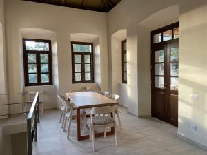 a dining room with a wooden table and chairs at The Red Cliffs Villa in Leonidio