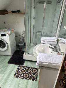 a bathroom with a washing machine and a sink at une détente à la campagne in Chierry
