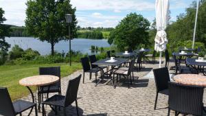 a row of tables and chairs with a view of a lake at Hotel am Untreusee in Hof