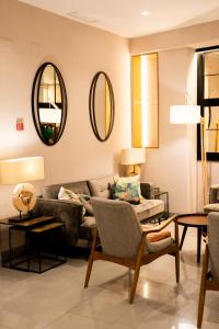 a living room with a couch and two mirrors at Hotel Puerta del Mar - Adults Recommended in Nerja